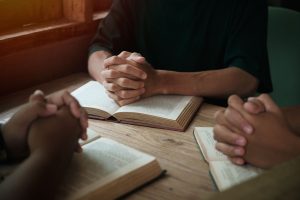 Christians are congregants join hands to pray and seek the blessings of God.
